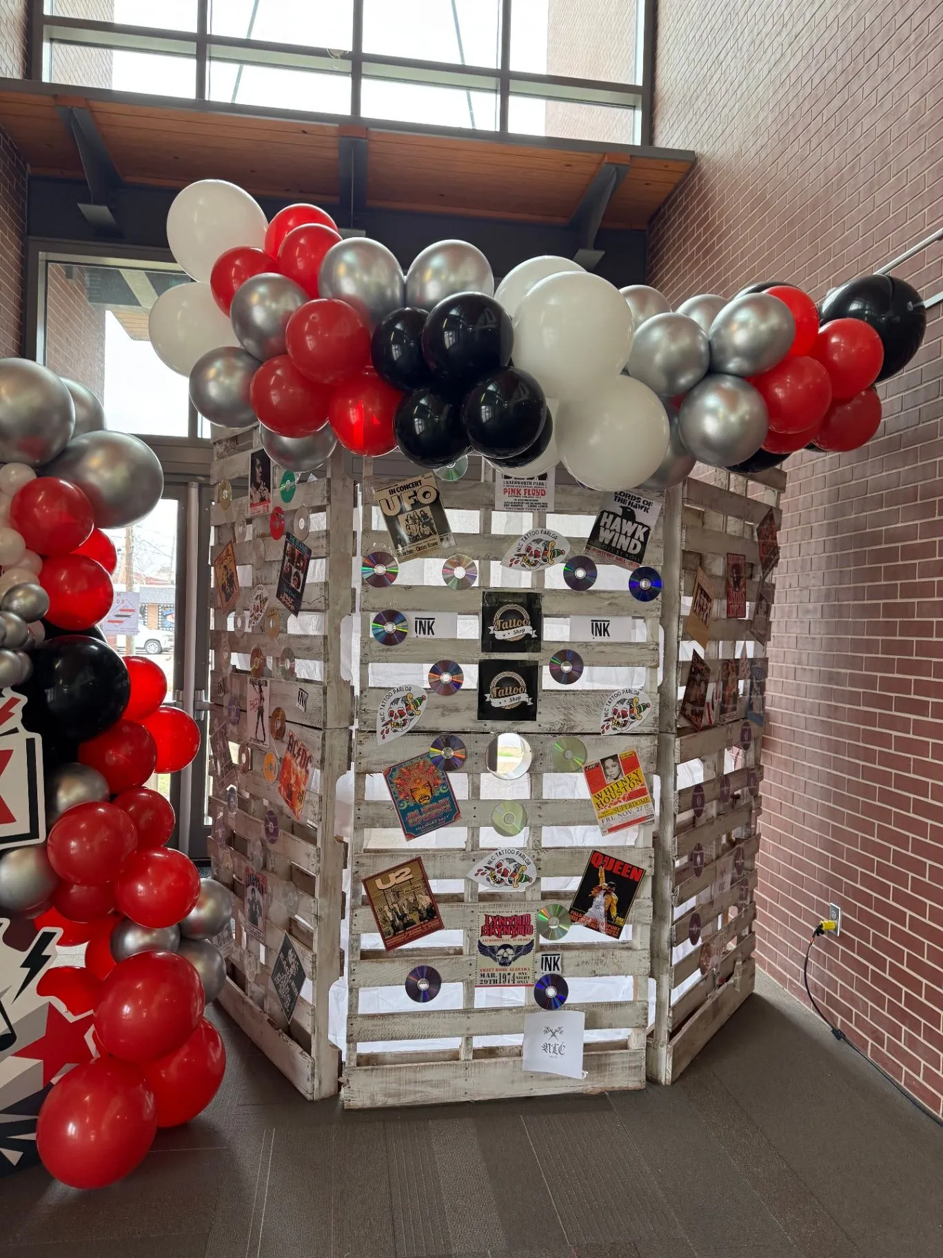 Basketball-themed birthday backdrop with striped step-and-repeat, colorful balloon garland, and children posing